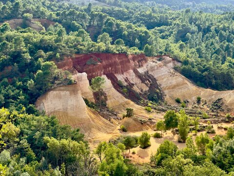Eroded ochre and white sandstone cliffs with a deep red band framed