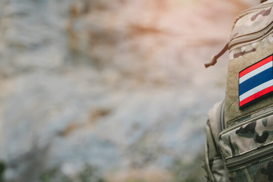 Outdoor military concept. Camouflage backpack with national flag patch on blurred outdoor background