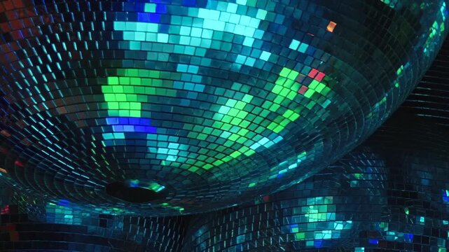 A dazzling birthday celebration unfolds at night inside a vibrant disco. Guests dance and enjoy the electrifying atmosphere created by colorful, shimmering lights reflecting from numerous disco balls.