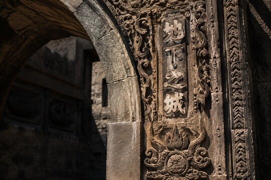 Ancient stone archway jamb with carved textures in sunlight.