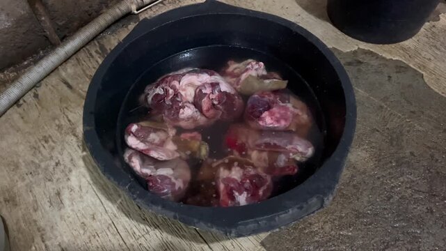 Cleaning fresh raw goat meat in black plastic basin close up