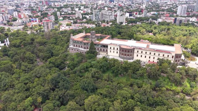 Aerial view of Chapultepec Castle and Mexico City skyline. Drone shot of historic castle, lush green park and skyscrapers on Paseo de la Reforma in CDMX.