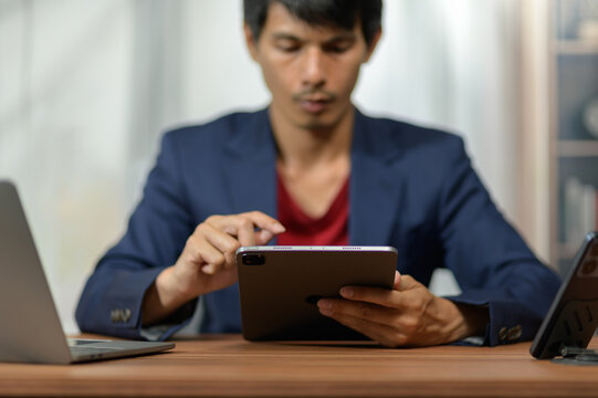 Young Man Using Digital Tablet for Work or Study in Modern Office Setting