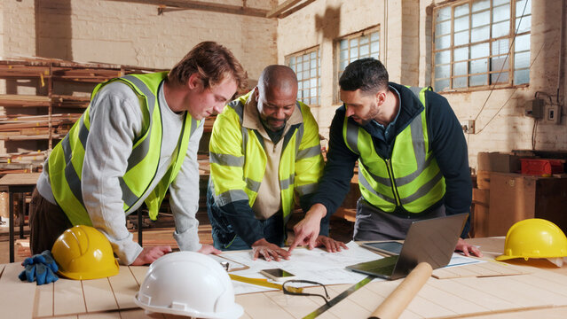 Paperwork, blueprint and men in workshop for carpentry, wood production and furniture design. Carpenter, contractor and people on laptop for inventory, timber project and planning for woodworking
