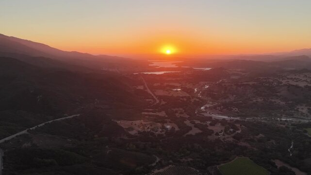 Aerial View of Santa Barbara County Hills at Sunset with Winding Road and Golden Light Over the Mountains