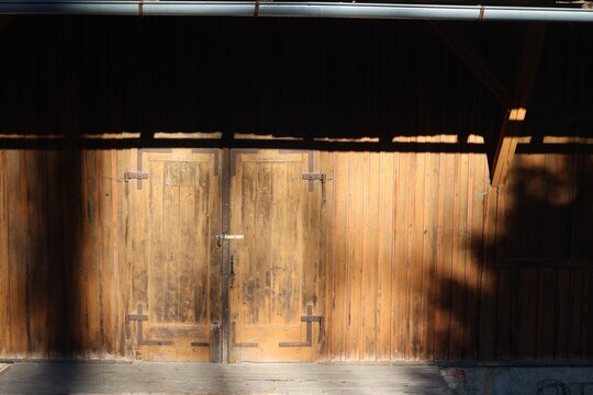 Old wooden barn doors with sunlight shadows