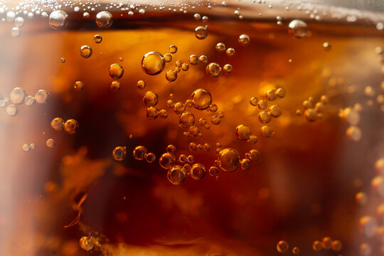 Macro Close Up of cola bubbles and ice cubes background