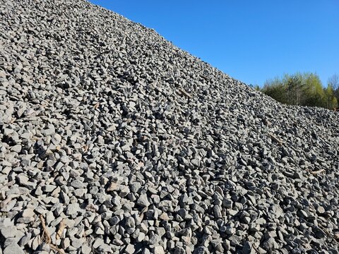 Rock pile on a sunny day in a gravel yard showing various sizes and textures