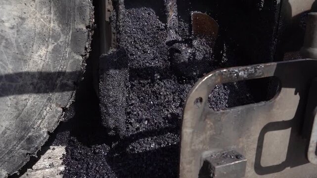 Heavy Equipment Mixing and Laying Hot Asphalt on Scraped Road. This industrial concept emphasizes technical precision, civil engineering, and road infrastructure restoration.