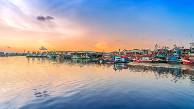 Colorful Fishing Boats Docked at Harbor During Vibrant Sunset