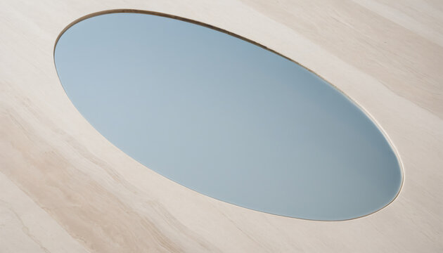 Oval mirror reflecting sky on a minimalist clay surface