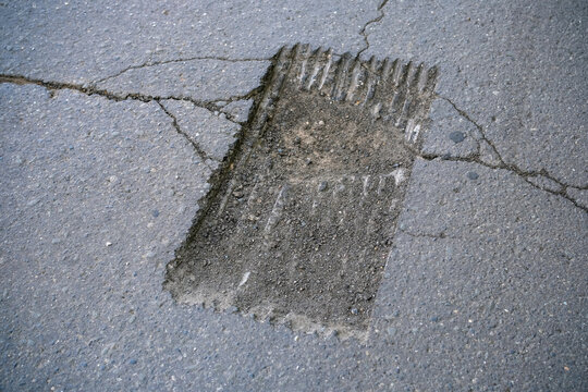 Milled section of asphalt road prepared for patch repair and new pavement installation. Close-up of roadway surface, road maintenance, reconstruction, infrastructure improvement and construction.