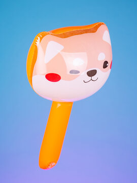 Close-up of an inflatable stick with a corgi dog head on a purple background. Bright, cute, and perfect for fun photos and playful moments.