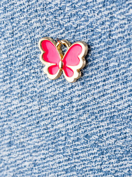 Close-up of a butterfly-shaped pendant for jewelry making, displayed on a blue background.