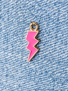 Close-up of a lightning bolt-shaped pendant for jewelry making, on a craft table