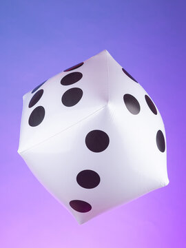 Close-up of an inflatable toy shaped like a gaming cube against a purple background. Playful and colorful decoration