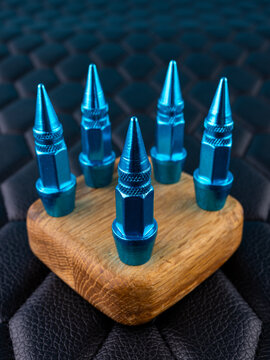 Close-up of blue metallic cap tips on a valve, spiked shape, against a black background.