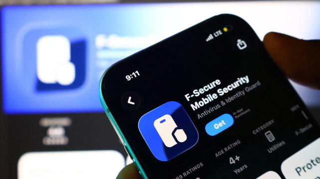 Smartphone held in hand displaying mobile application store page for f-secure mobile app.