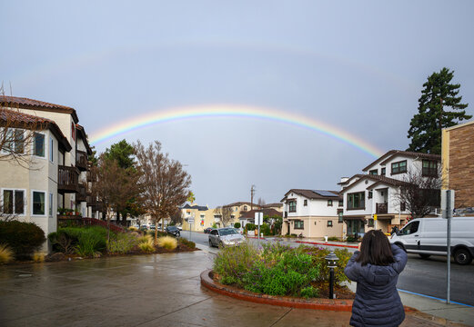Double rainbows on the sky. Woman taking photos of the rainbow. California.