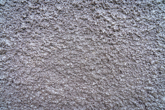 Close-up of gray textured plaster wall with a rough surface and natural imperfections, suitable for abstract backgrounds, architectural design, and construction themes.
