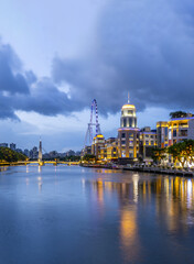 Obraz premium Night view of the Ferris wheel and clock tower along the Shiqi River in Zhongshan City, China
