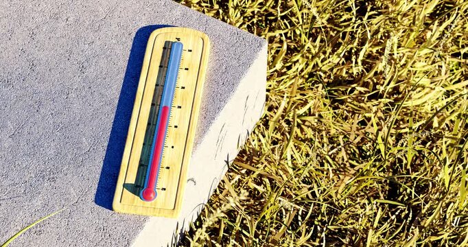 3D animated illustration of wooden thermometer rising to 41 degrees celsius on hot stone surface with dry grass during extreme summer heatwave
