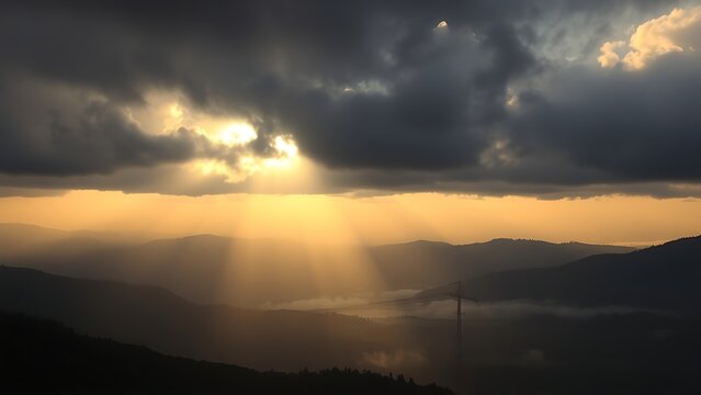 Morning sun rays breaking through dark clouds over a misty valley.