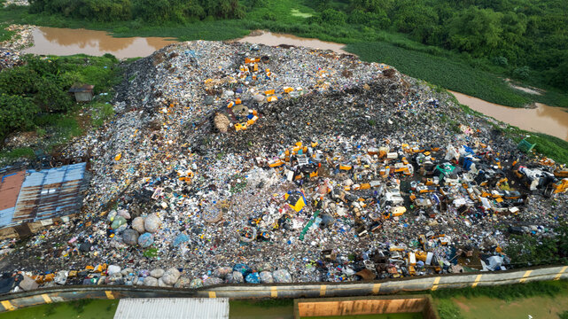 Aerial view of a massive landfill site near the Alagbole bridge, featuring piles of waste, plastic debris, and discarded materials situated along a riverbank in Lagos, Ogun State, Nigeria.