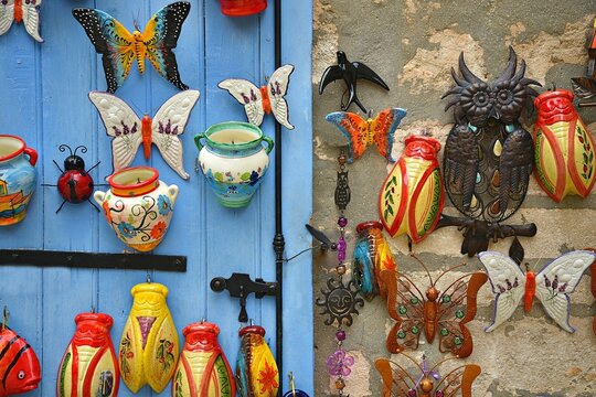 Handmade glazed ceramic cicadas on a wooden window shutter and on the stone wall in the traditional village Les Baux-de-Provence in Bouches-du-Rh&ocirc;ne, Alpes-C&ocirc;te d'Azur France.