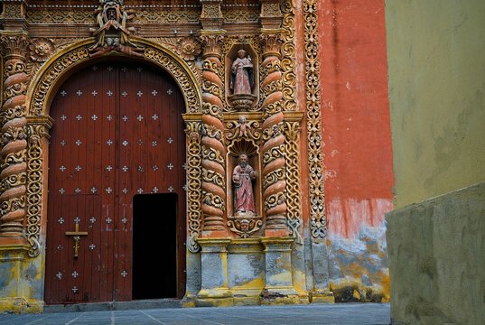 Arched portal facade of the Baroque style Capilla de la Tercera Orden de San Francisco decorated with mortar sculptures and engravings in Atlixco Mexico.