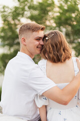 Fototapeta premium Young couple embracing outdoors with a warm smile and gentle touch