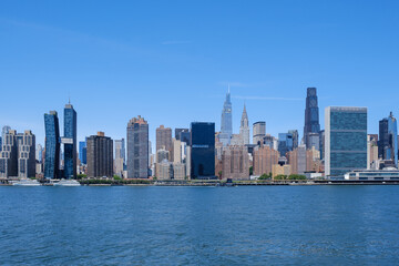 Obraz premium Panoramic daytime view of the Midtown Manhattan skyline featuring the UN headquarters and modern skyscrapers from the East River, New York.