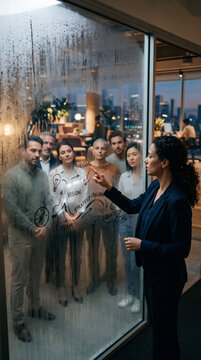 Manager Planning Business Path on Glass Wall with Team Reflections
