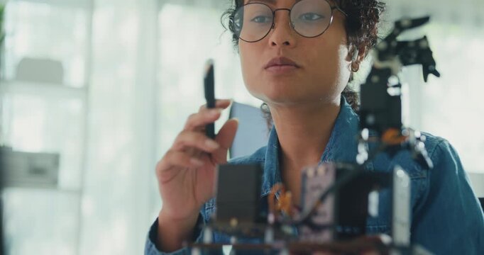 Close-up African American female robotics engineer discussing mechanical part on video call in laboratory. Remote work, virtual training, online meeting, future technology, technical support concept.