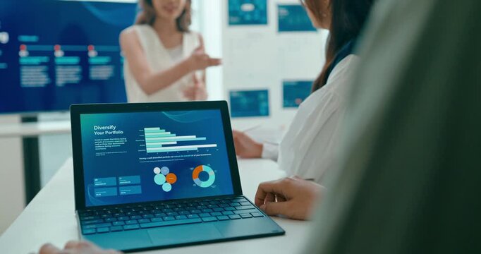 Closeup group Asian businesspeople work together discuss plan idea with investment profit sale statistics in business meeting in office. Financial generation z team brainstorm on e-Commerce project.