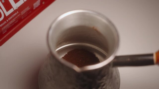 Ground coffee poured into cezve