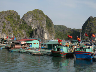Floating fishing village with boats in Halong Bay Vietnam © Simon