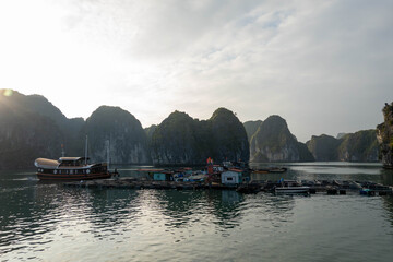 Floating fishing village in Halong Bay with karst limestone cliffs © Simon