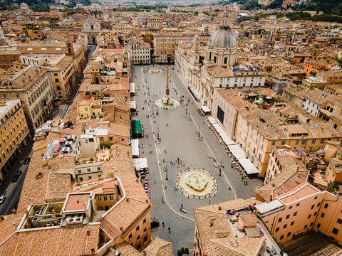 Aerial view of Piazza Navona featuring the Fountain of the Four Rivers and the Fountain of the Moor surrounded by historic buildings and terracotta rooftops in Rome, Lazio, Italy.