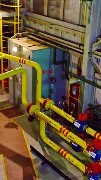 Comprehensive visual of factory machinery and colored piping systems. An extensive depiction of engine room showcasing intricate piping structures within industrial factory setting