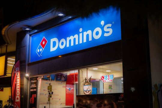 Athens, Greece-October 25,2024.Facade of a Domino's pizzeria with illuminated lights photographed at night.