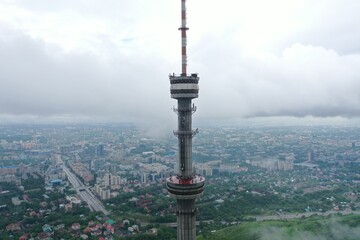 Fototapeta premium Aerial View of Kok Tobe Tower Rising Above Urban Landscape Under Cloudy Sky, Almaty, Kazakhstan