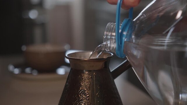 Pouring-water-into-turkish-coffee-pot-close-up