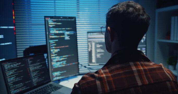 Close up young Male programmer hands typing on keyboard in dark home office at night. AI technology, cybersecurity, software developer, freelance innovation, database system, digital network concept.