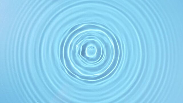 blue water drop falling down in slow motion, water ripples background.	