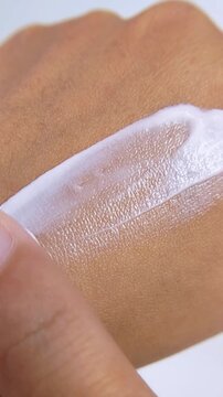 Close up process of applying moisturizing cream to dry hand skin. Hydrating cream for beauty product theme, daily skincare routine for soft healthy hands.