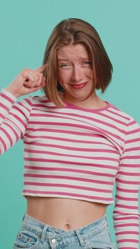 You are crazy, out of mind. Displeased woman pointing at camera, show stupid gesture finger near head, blaming some idiot for dumb insane plan idea, senseless talk. Lady isolated on blue background