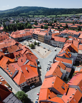 Aerial view of the historic town square surrounded by red-tiled rooftops and cobblestone streets in Prachatice, South Bohemian Region, Czechia.