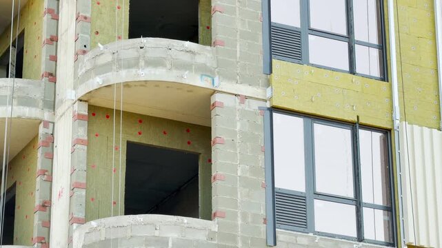 A construction site reveals a building under development with raw walls and modern windows. This industrial scene evokes feelings of anticipation, progress, and the gritty beauty of urban evolution.