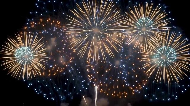 Bright golden and blue fireworks exploding in the night sky creating a stunning motion video clip of celebration and joy